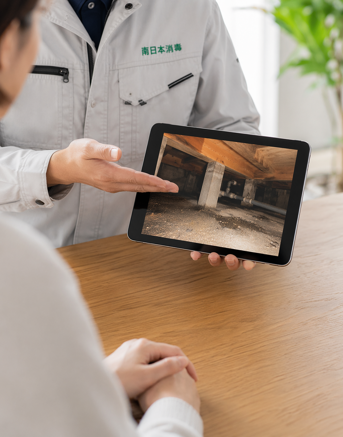 南日本消毒スタッフがiPadで床下の状況をお客様に説明している様子
