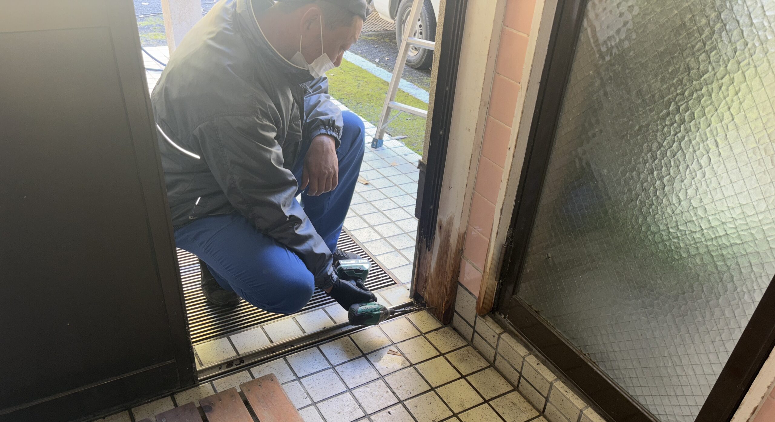 床下点検口からシロアリ防除の薬剤処理を行う作業員（鹿児島）